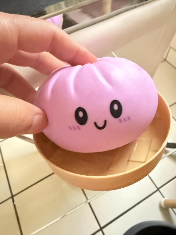 Close-up of pink kawaii bao bun squishy being squeezed - slow rising sensory fidget toy detail
